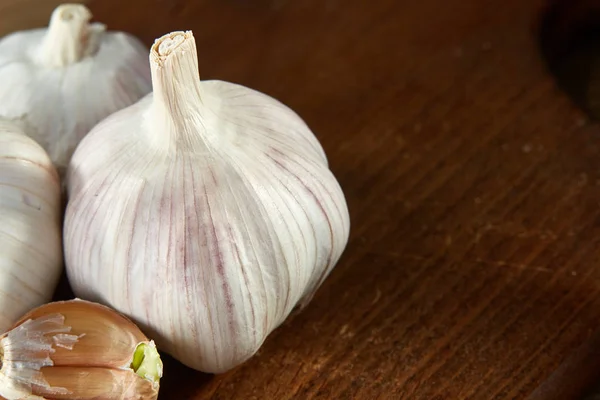 Sarımsak yakın çekim rustik arka plan, sığ derinliği alan, seçici odak, makro üzerinde ahşap plaka üzerinde — Stok fotoğraf