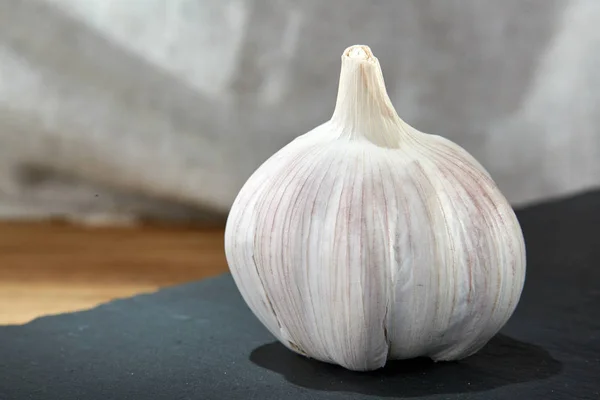 Sarımsak yakın kara tahta, sığ derinliği alan, seçici odak, makro ahşap plaka üzerinde çekim — Stok fotoğraf