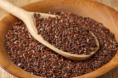 Tahta kaşıkla bir tabak rustik arka plan, üstten görünüm, yakın çekim, sığ derinlik-in tarla içinde keten tohumu