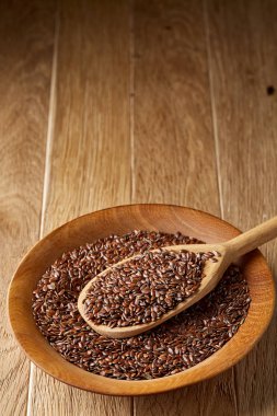 Tahta kaşıkla bir tabak rustik arka plan, üstten görünüm, yakın çekim, sığ derinlik-in tarla içinde keten tohumu