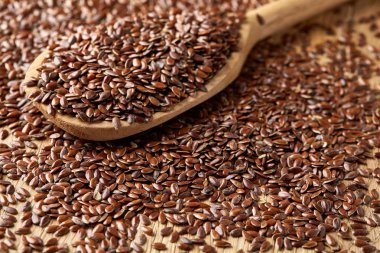 Ahşap kase ve rustik ahşap arka plan, üstten görünüm, sığ derinlik-in tarla kaşık keten tohumu