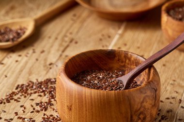 Ahşap kase ve rustik ahşap arka plan, üstten görünüm, sığ derinlik-in tarla kaşık keten tohumu