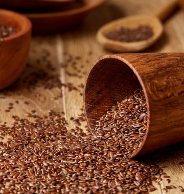 Linseeds bir rustik arka plan, yakın çekim, sığ alan, seçici odak derinliği ile devrilmiş bir ahşap kase