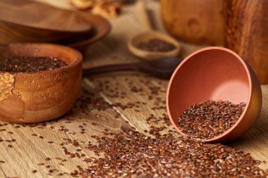 Linseeds bir rustik arka plan, yakın çekim, sığ derinlik-in tarla, seçici odak ile devrilmiş bir seramik kase