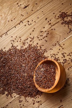 Linseeds bir rustik arka plan, yakın çekim, sığ alan, seçici odak derinliği ile devrilmiş bir ahşap kase