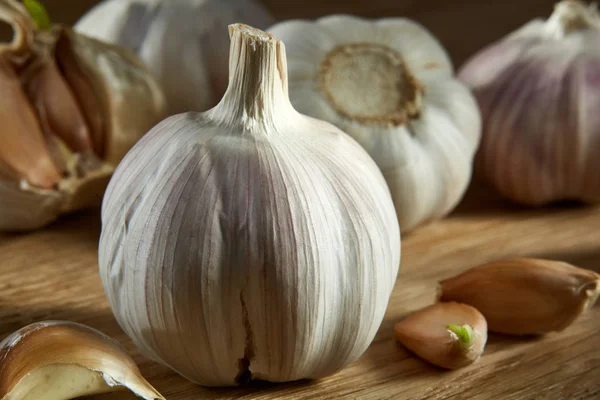 Knoflook close-up op rustieke houten achtergrond, ondiepe diepte van veld, selectieve aandacht, macro — Stockfoto