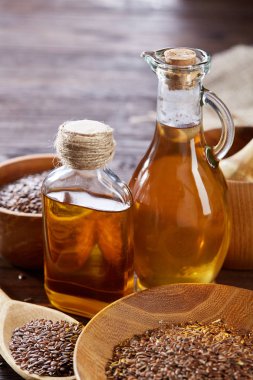 Ahşap arka plan, üstten görünüm, yakın çekim, seçici odak cam şişede kase ve keten tohumu yağı keten tohumu