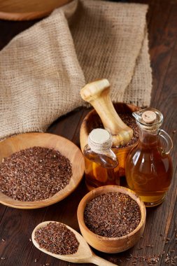 Ahşap arka plan, üstten görünüm, yakın çekim, seçici odak cam şişede kase ve keten tohumu yağı keten tohumu