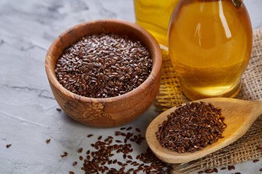 Ahşap arka plan, üstten görünüm, yakın çekim, seçici odak cam şişede kase ve keten tohumu yağı keten tohumu