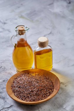 Ahşap arka plan, üstten görünüm, yakın çekim, seçici odak cam şişede kase ve keten tohumu yağı keten tohumu