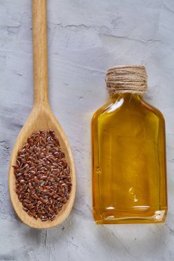Ahşap arka plan, üstten görünüm, yakın çekim, seçici odak cam şişede kase ve keten tohumu yağı keten tohumu