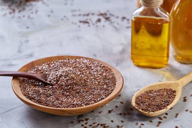 Ahşap arka plan, üstten görünüm, yakın çekim, seçici odak cam şişede kase ve keten tohumu yağı keten tohumu