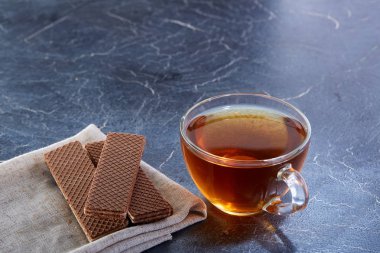 Siyah çay tanımlama karanlık grimsi mermer zemin ile cam fincan. Kahvaltı arka plan