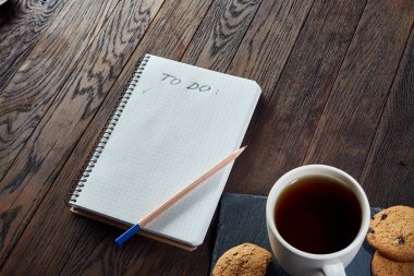 Tanımlama bilgileri, çalışma kitabı ve kalemin ahşap arka plan, üstten görünüm üzerinde çay