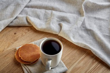 Pamuk peçeteye bir rustik ahşap arka plan, üstten görünüm, dikey olarak waffle ile porselen çay fincanı