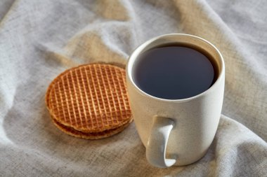 Pamuk peçeteye bir rustik ahşap arka plan, üstten görünüm, dikey olarak waffle ile porselen çay fincanı