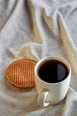 Pamuk peçeteye bir rustik ahşap arka plan, üstten görünüm, dikey olarak waffle ile porselen çay fincanı