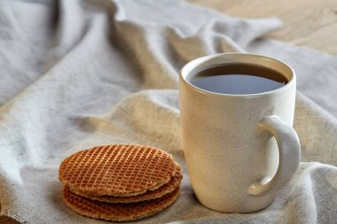 Pamuk peçeteye bir rustik ahşap arka plan, üstten görünüm, dikey olarak waffle ile porselen çay fincanı