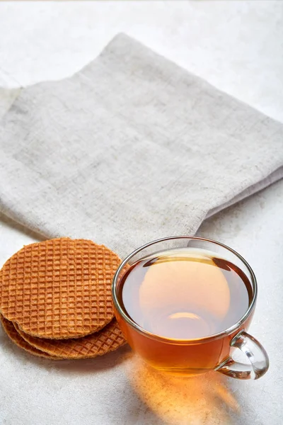 Top view closeup picture of tea in transparent cup with cookies and cotton napkin on white background, selective focus — Stock Photo, Image
