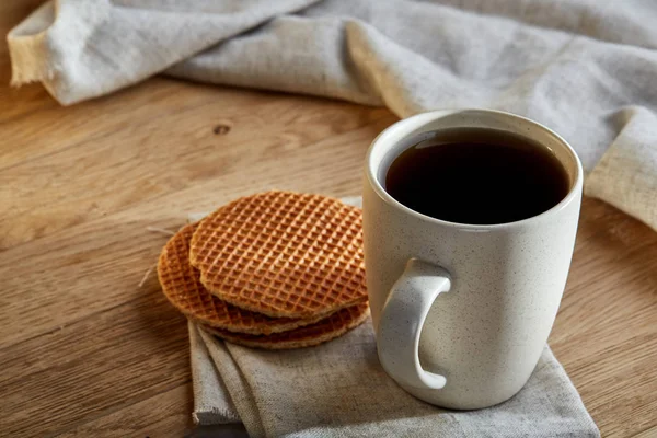 Pamuk peçeteye bir rustik ahşap arka plan, üstten görünüm, dikey olarak waffle ile porselen çay fincanı