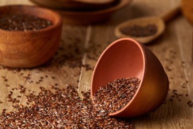 Linseeds bir rustik arka plan, yakın çekim, sığ derinlik-in tarla, seçici odak ile devrilmiş bir seramik kase