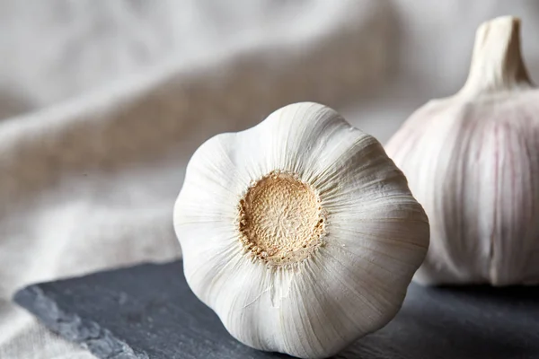 Knoflook close-up op houten plaat op de zwarte plaat, ondiepe diepte van veld, selectieve aandacht, macro — Stockfoto