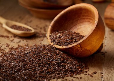 Linseeds bir rustik arka plan, yakın çekim, sığ alan, seçici odak derinliği ile devrilmiş bir ahşap kase