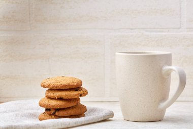 Yakın çekim beyaz fincan kahve ile lezzetli çikolatalı kurabiye beyaz arka planda, üstten görünüm