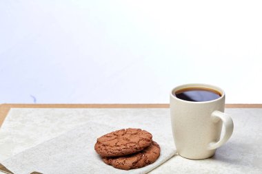 Yakın çekim beyaz fincan kahve ile lezzetli çikolata kurabiye beyaz arka planda, üstten görünüm