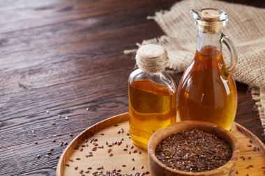 Ahşap arka plan, üstten görünüm, yakın çekim, seçici odak cam şişede kase ve keten tohumu yağı keten tohumu