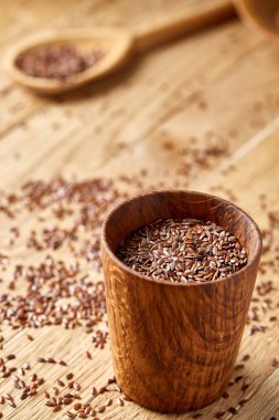 Ahşap kase rustik ahşap arka plan, üstten görünüm, sığ derinlik-in tarla içinde keten tohumu