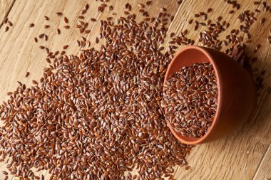 Linseeds bir rustik arka plan, yakın çekim, sığ alan, seçici odak derinliği ile devrilmiş bir ahşap kase