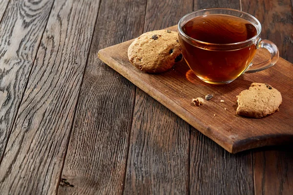 Xícara de chá com biscoitos em uma placa de corte de madeira no fundo do vintage, vista superior — Fotografia de Stock