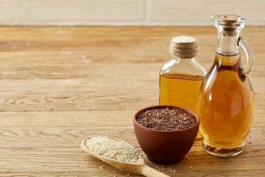 Kase, cam şişe, ahşap arka plan yükselişte kaşıkla, yakın çekim, seçici odak keten tohumu yağı keten tohumu