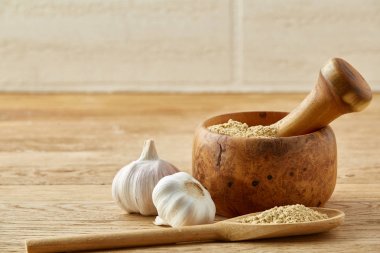 Ahşap harç ve havaneli ile sarımsak ve eziyet baharat rustik masa, yakın çekim, seçici odak