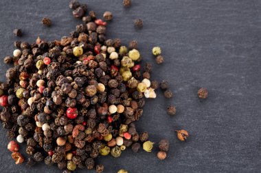 En koyu arka plan üzerinde tahta kaşık karabiber bileşimi görünüm yakın çekim.