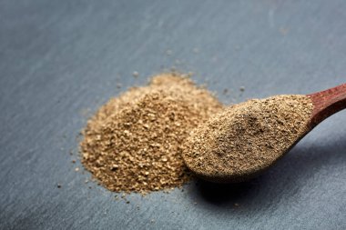 En koyu arka plan üzerinde tahta kaşık karabiber bileşimi görünüm yakın çekim.