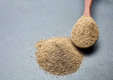 En koyu arka plan üzerinde tahta kaşık karabiber bileşimi görünüm yakın çekim.