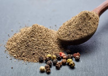 En koyu arka plan üzerinde tahta kaşık karabiber bileşimi görünüm yakın çekim.