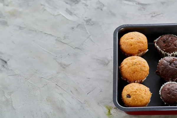 Muffins au chocolat frais cuits au four sur une plaque à biscuits, vue de dessus, gros plan, mise au point sélective — Photo