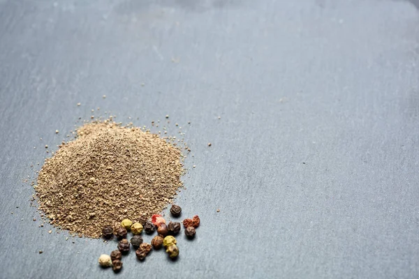 Vista superior de la composición de granos de pimienta en cuchara de madera sobre fondo oscuro, primer plano . — Foto de Stock