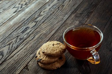 Rustik ahşap arka plan, üstten görünüm peçeteye pamuk üzerinde Çerezler çikolata ile cam çay fincanı fişleri