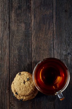 Rustik ahşap arka plan, üstten görünüm peçeteye pamuk üzerinde Çerezler çikolata ile cam çay fincanı fişleri