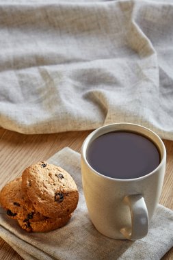 Rustik ahşap arka plan, üstten görünüm peçeteye pamuk üzerinde çerezleri porselen çay fincanı çikolata ile cips