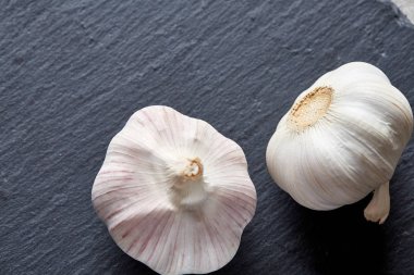 Düzenlenmiş siyah bir tahta parçası, alan, seçici odak, makro sığ derinliği iki sarımsak ampuller görünümünü kapat