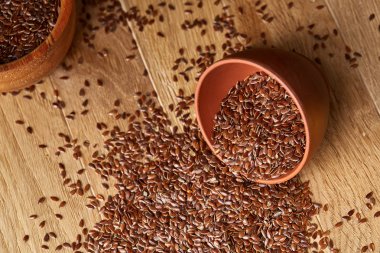 Linseeds bir rustik arka plan, yakın çekim, sığ derinlik-in tarla, seçici odak ile devrilmiş bir seramik kase