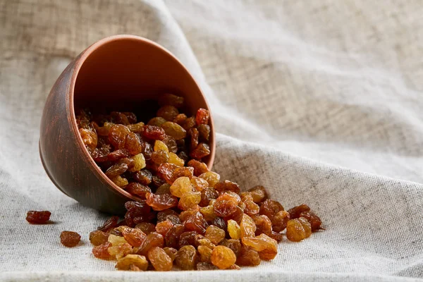 Ceramic bowl with golden raisins on light tablecloth, close-up, selective focus — Stock Photo, Image