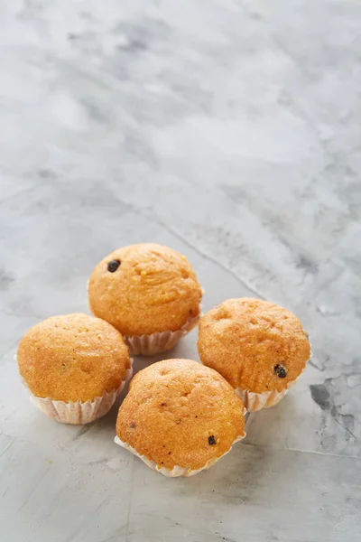 Lekkere muffins gerangschikt in patroon op licht gestructureerde achtergrond, close-up, ondiepe diepte van veld, selectieve aandacht. — Stockfoto
