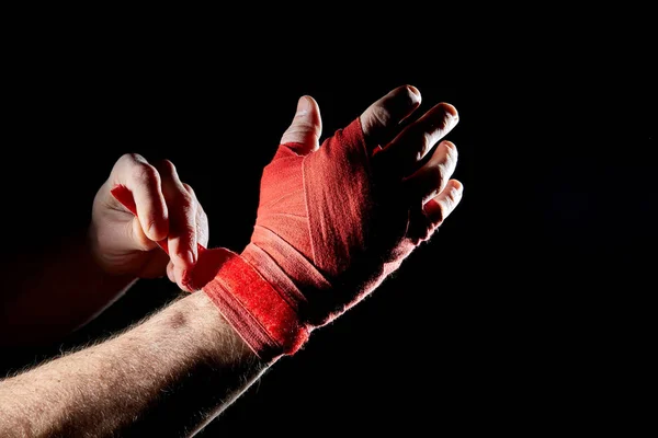 Un vendaje rojo boxeador en su mano aislado sobre fondo oscuro borroso, primer plano . — Foto de Stock