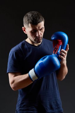 Düşük anahtar stüdyo portre yakışıklı kaslı dövüşçülerin korku koyu arka plan bulanık boks için hazırlanıyor